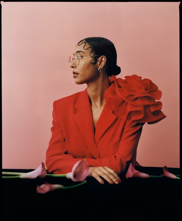 the gallerist and curator Hannah Traore wearing a red suit and looking to the side