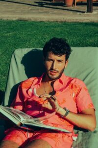 Sebastián Yatra in a salmon colored button down shirt