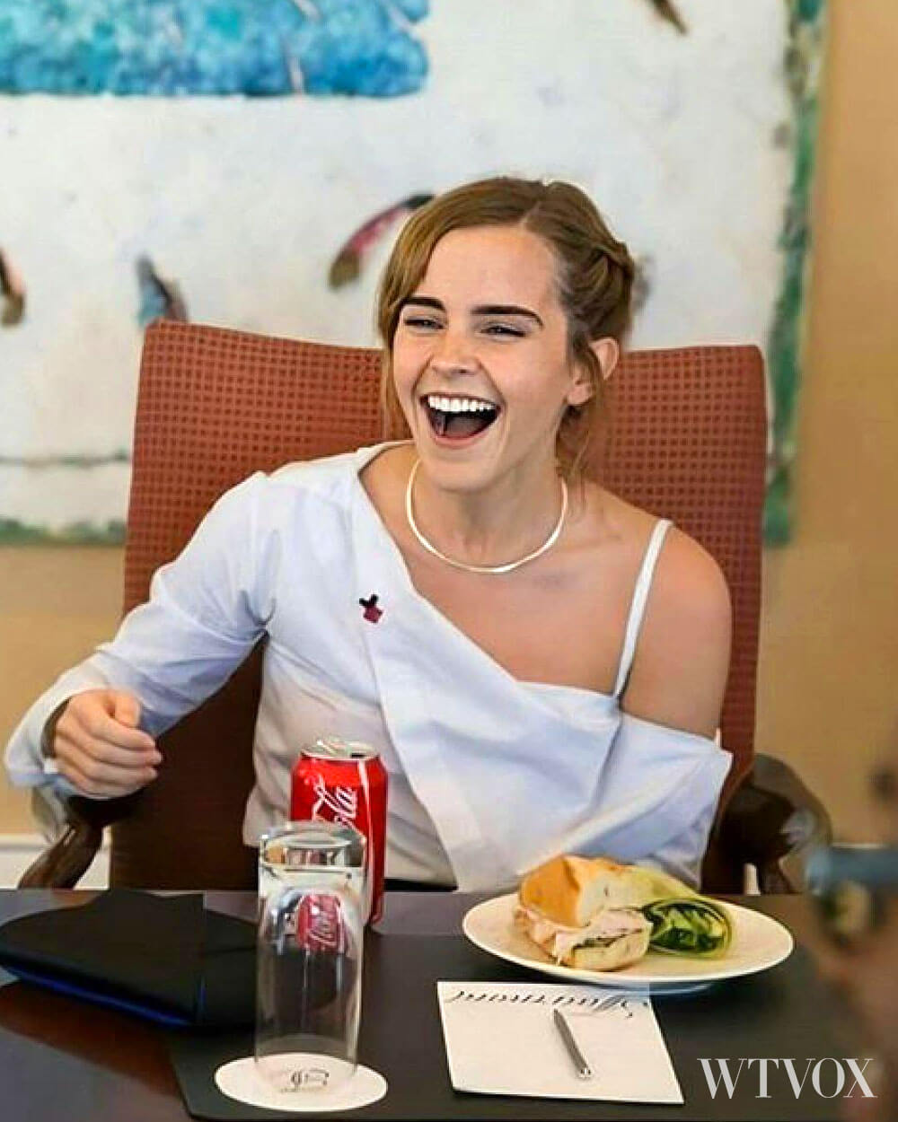 Emma Watson eating a ham sandwich and drinking a can of coca cola.