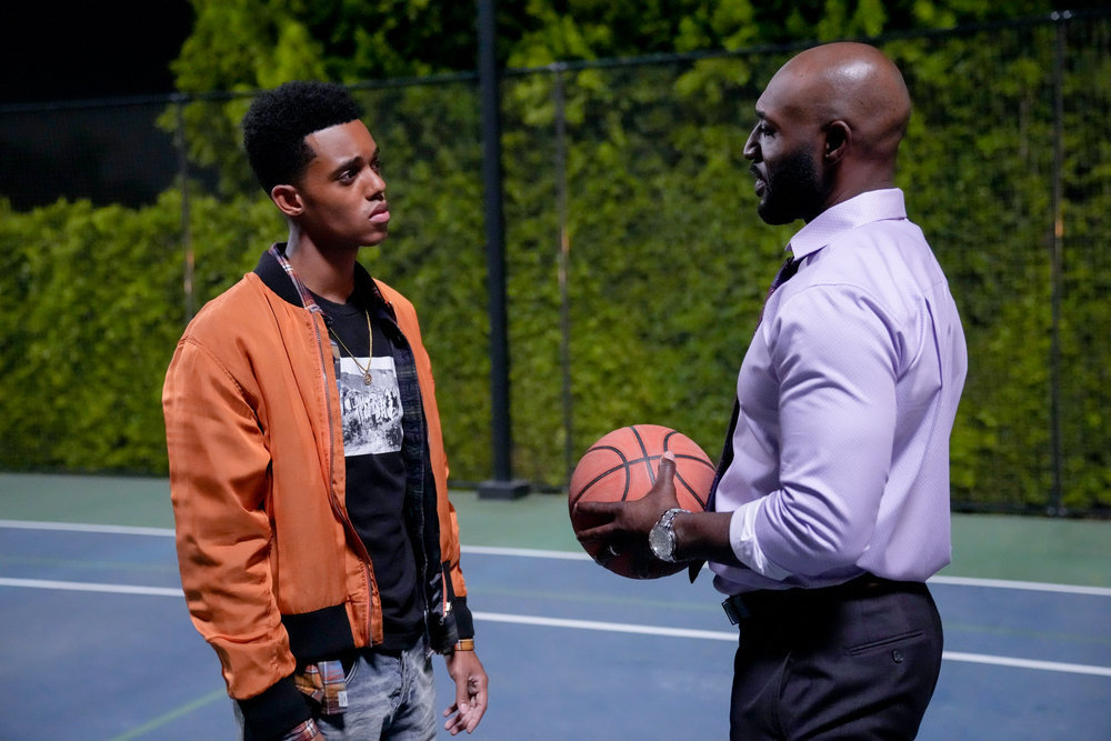 Jabari Banks and Adrian Holmes as Will Smith and Uncle Phil stand on a basketball court at the Banks home