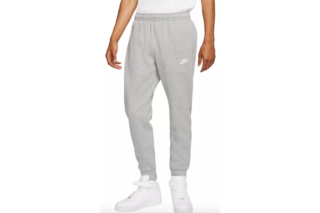A man's lower body in gray Nike joggers 