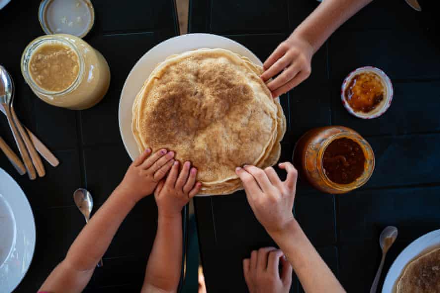 Kids reaching for crepes at breakfastTop view of kids reaching for crepes at a breakfast table.