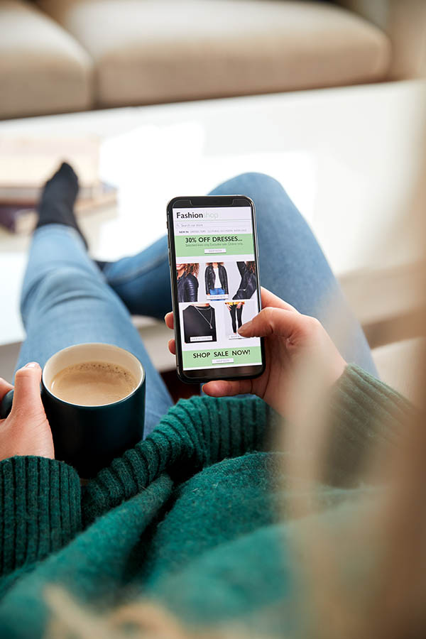 Close up of woman shopping clothes online with her smartphone.