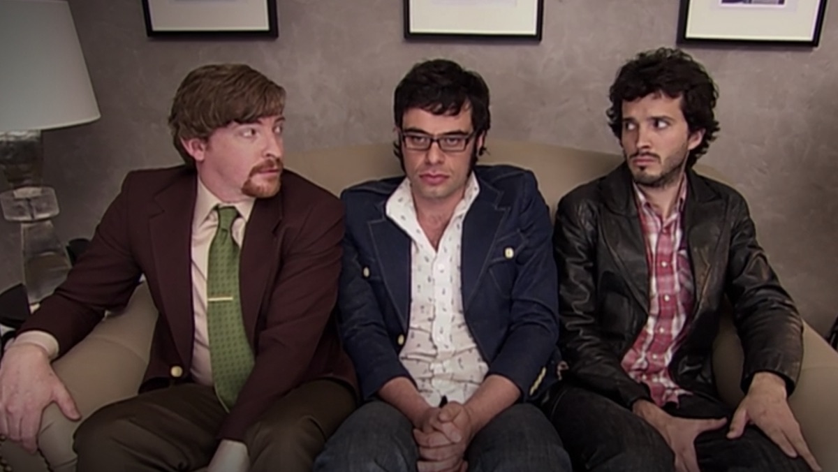 Murray, Jemaine, and Bret sit on a small couch on Flight of the Conchords