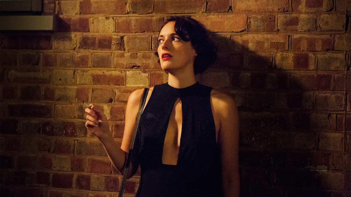 Phoebe Waller-Bridge smokes a cigarette with her back to a brick wall.
