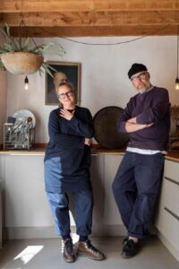 Cooking up a storm: Nicola Helgesen and Andreas Bleckmann in the kitchen. Nicola was a fashion designer before she made the move to the south coast, and has now created a business, Oldtownhaus, that sells vintage and antique objects that fit in with the aesthetic of their home. Andreas is a photographer.
