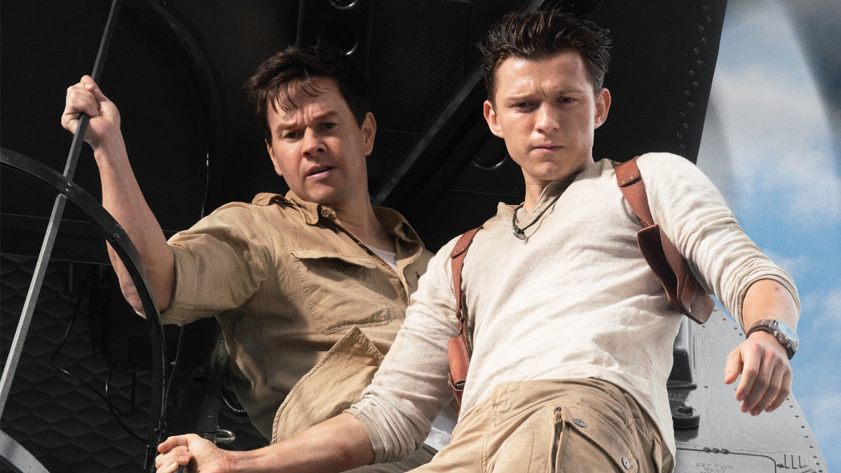 Mark Wahlberg and Tom Holland hold onto ropes on a ship in Uncharted