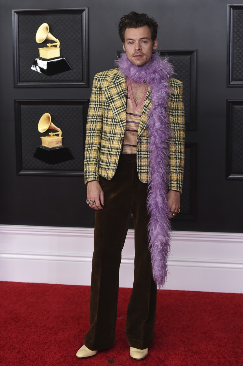 A man wears a purple feather boa and a yellow blazer