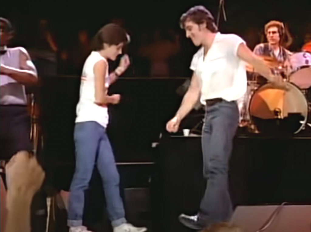 Courteney Cox and Bruce Springsteen dancing on stage