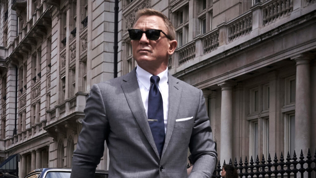 Daniel Craig in a light colored suit wearing sunglasses