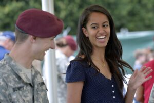 Malia Obama, daughter of US President, (R) smiles as she serves food during a lunch at the United States and Nato military base in Vicenza  on June 19, 2015 .   AFP PHOTO / ANDREAS SOLARO        (Photo credit should read ANDREAS SOLARO/AFP via Getty Images)