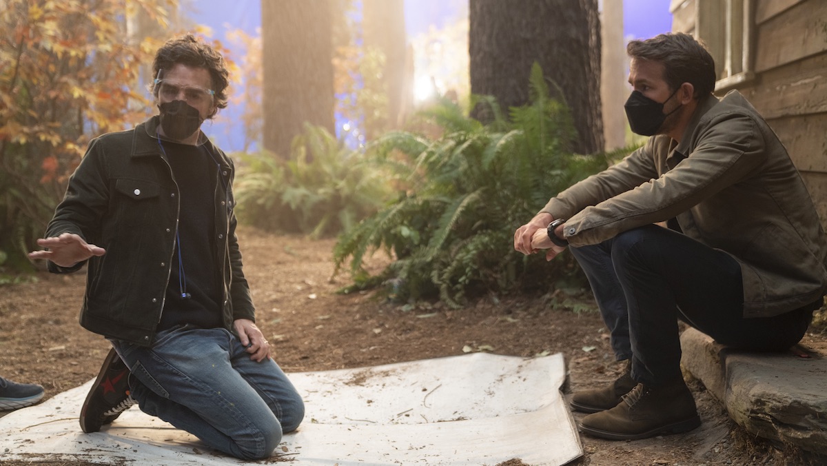 Shawn Levy kneels down while giving Ryan Reynolds notes on the set of The Adam Project