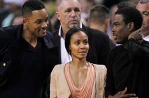 Actor Will Smith, left, actress Jada Pinkett Smith, center, and actor Chris Rock during the second quarter of Game 5 in their NBA basketball Eastern Conference semifinal playoff series in Boston, Monday, May 21, 2012. (AP Photo/Charles Krupa)