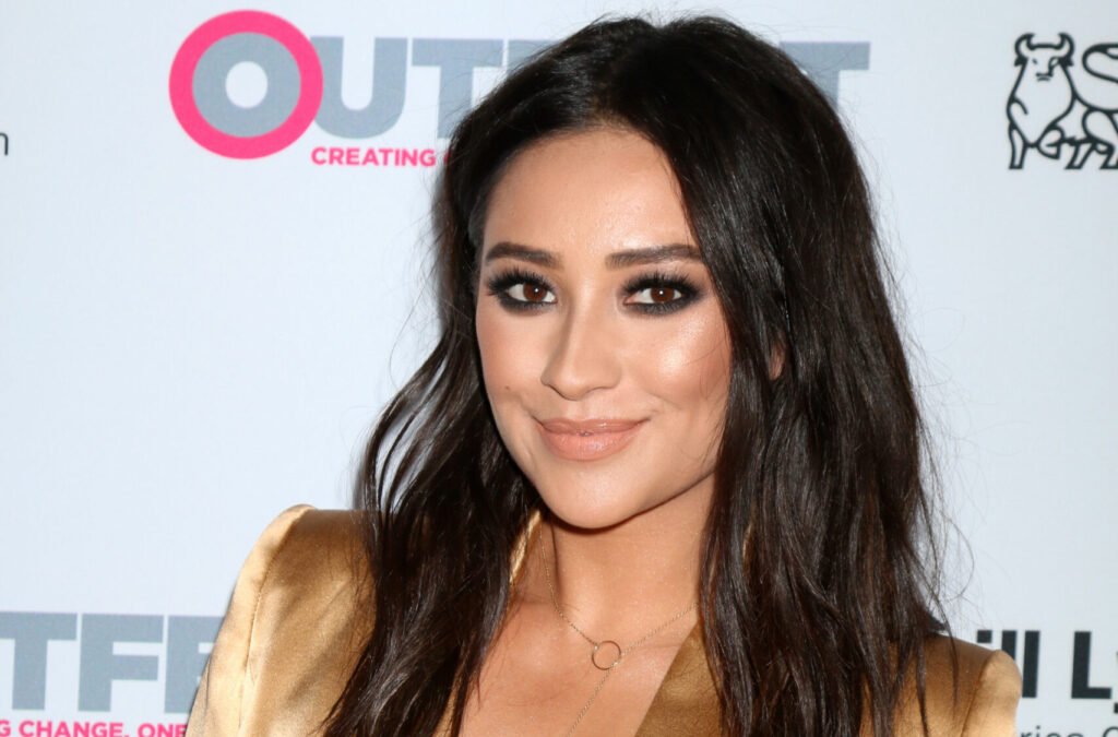 Shay Mitchell wearing a gold blazer and thick eyeliner in 2016