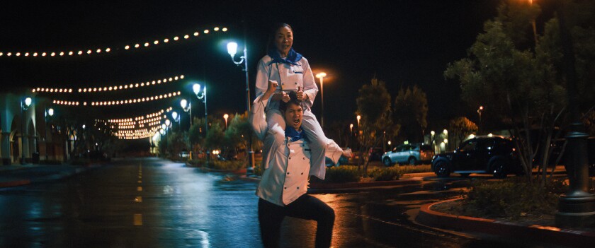 Michelle Yeoh rides Harry Shum Jr.'s shoulders in a scene from "Everything Everywhere All at Once." 