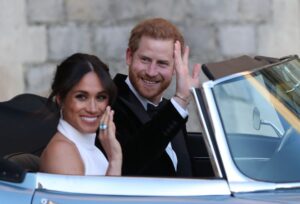 The Duke and Duchess of Sussex wave as they leave Windsor Castle after their wedding to attend an evening reception at Frogmore House on May 19, 2018.