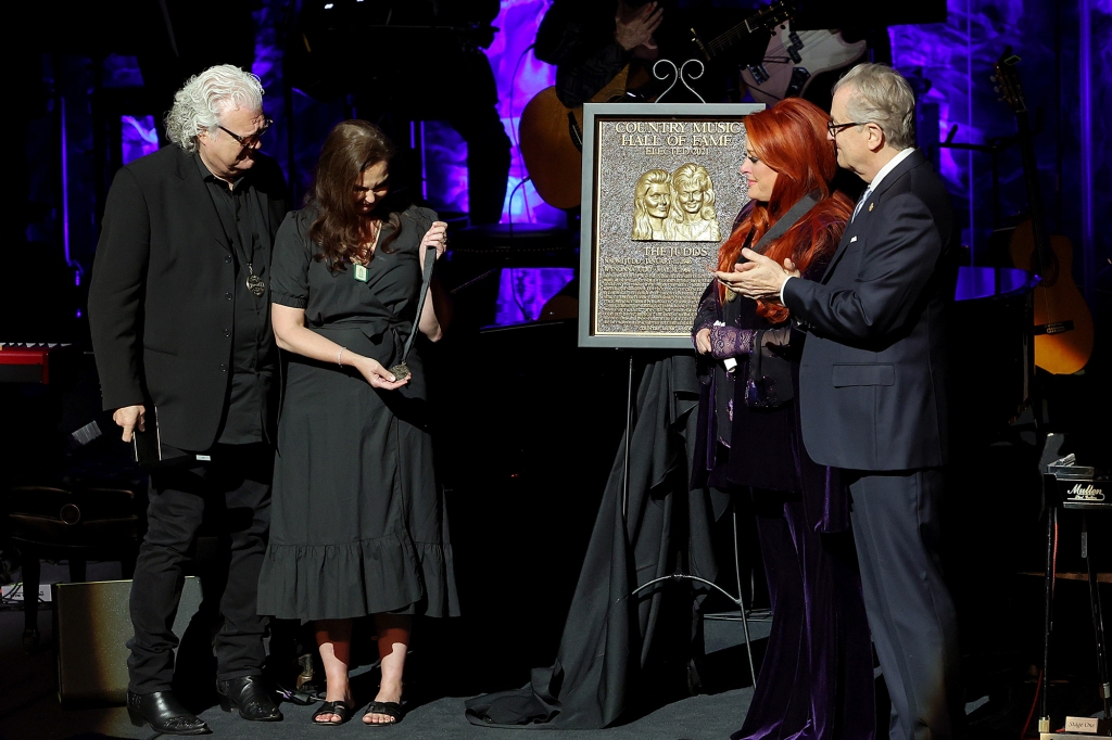 NASHVILLE, TENNESSEE - MAY 01: Ashley Judd (CL) accepts induction on behalf of Naomi Judd with Ricky Skaggs(L), inductee Wynonna Judd and CEO of the Country Music Hall of Fame and Museum Kyle Young onstage for the class of 2021 medallion ceremony at Country Music Hall of Fame and Museum on May 01, 2022 in Nashville, Tennessee. (Photo by Jason Kempin/Getty Images for Country Music Hall of Fame and Museum)