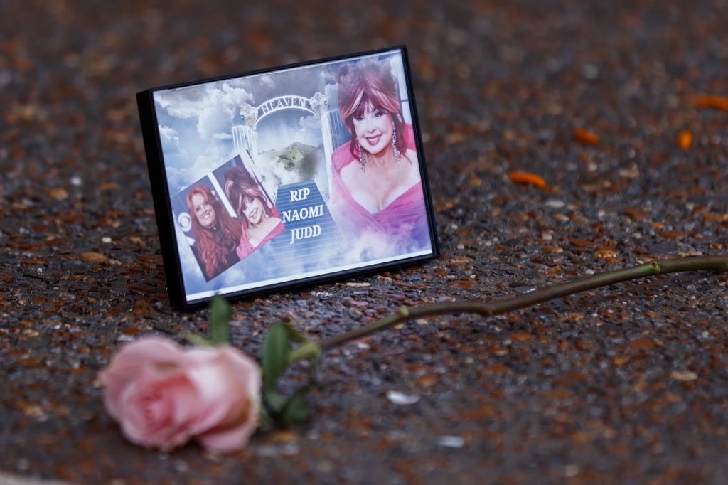 A photograph of Naomi Judd lays with a rose outside the Country Music Hall of Fame before the medallion ceremony on Sunday, May 1, 2022.