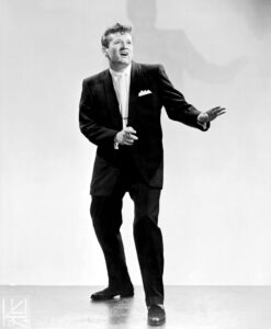 A male singer poses in a suit