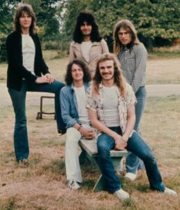 Alan White, seated in blue jeans, with Yes in 1974.