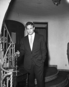 Marlon Brando standing next to his Oscar in 1954
