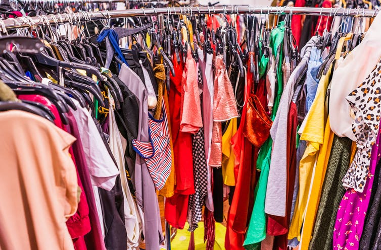 Cluttered rack of colourful fast fashion clothing