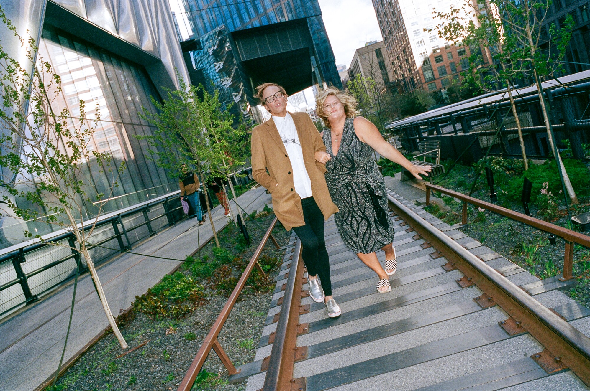 A man and woman walking on the NYC Highline.