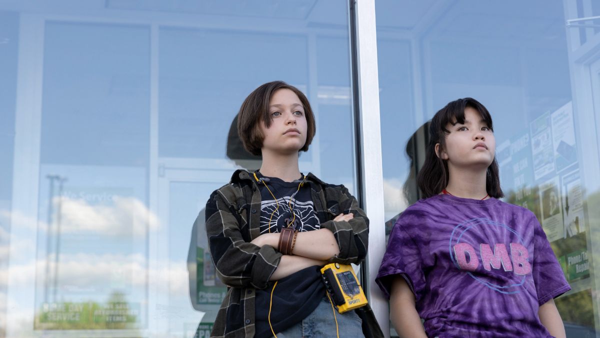 mac and erin stand against a window in paper girls tv show photo