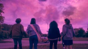 four girls standing and looking at pinkish blue sky in paper girls show