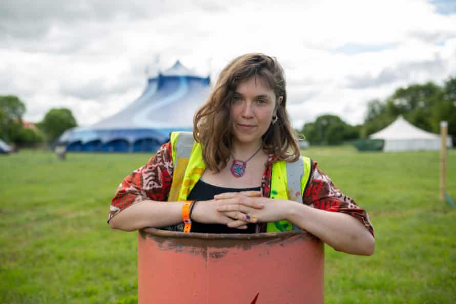 Bethany Stenning, a bin painter who will perform with Ishmael Ensemble at the West Holts stage on Sunday morning, peeks out from inside a bin.