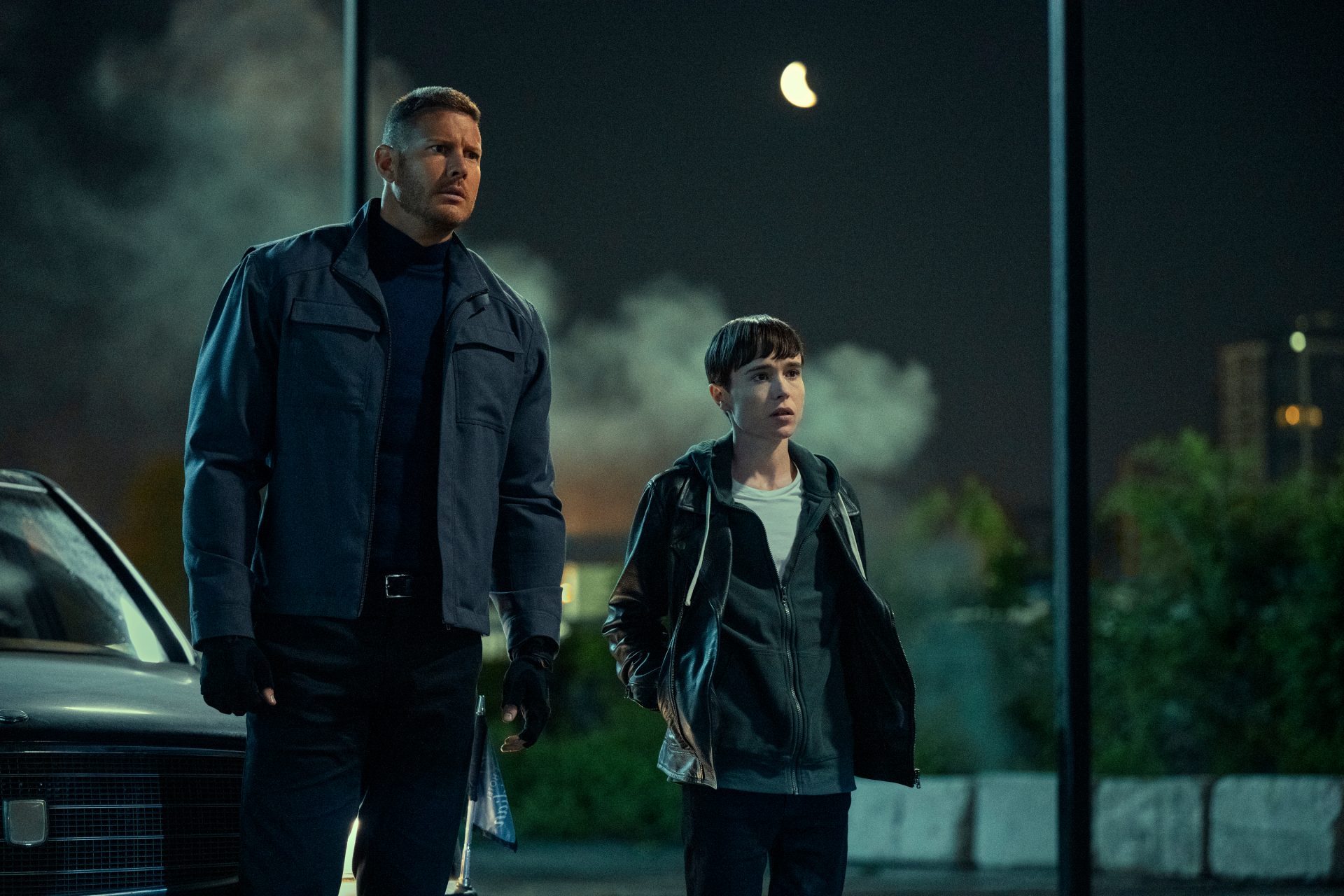 Tom Hooper as Luther stands next to Elliot Page as Viktor in The Umbrella Academy Season Three