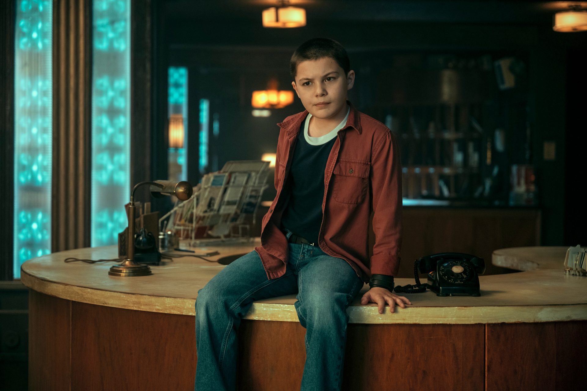 Umbrella Academy first look images - Harlan Cooper, a child, sitting on a table