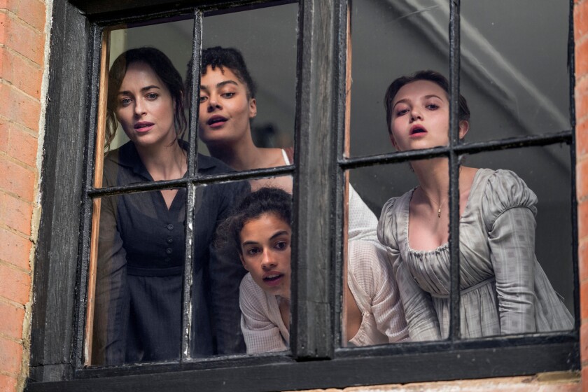 Four women look out a window.