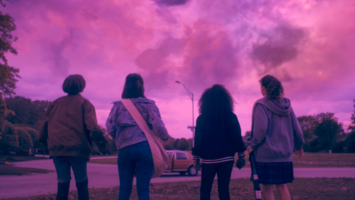 four girls look up at a pinkish purple sky in paper girls teaser
