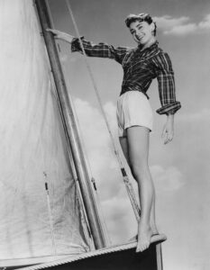 Audrey Hepburn poses barefoot on a sailing boat on the set of the film