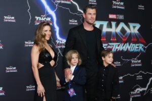 Elsa Pataky, Chris Hemsworth and their children Sasha and Tristan stand on red carpet, all dressed in dark blue and black