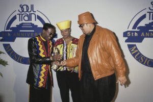 Johnny Gill (L), Queen Latifah (Dana Elaine Owens), wearing a yellow hat and sunglasses, and Heavy D (Dwight Arrington Myers