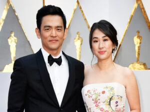Actors John Cho (L) wearing classic blasck suit and Kerri Higuchi, who is wearing a white gown with floral pattern