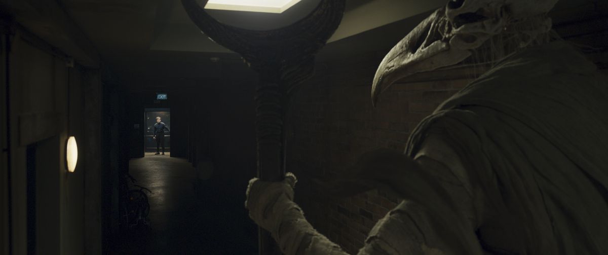 Khonshu stands at the end of a hallway, looking at Steven Grant from a distance in Marvel Studios’ Moon Knight.