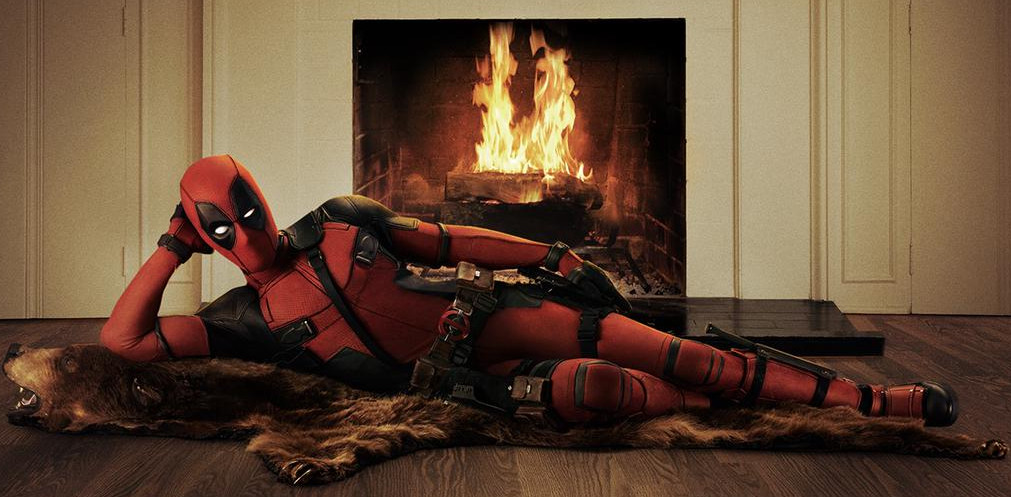 Ryan Reynolds’ Deadpool reclines coquettishly on a bear rug in front of a roaring fire. 