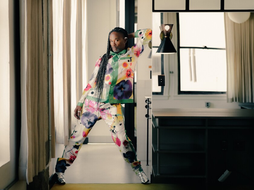 A person in a colorful floral outfit photographed in a hotel room.