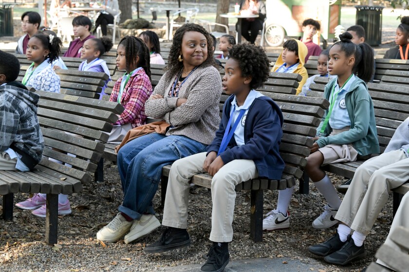 A teacher on park benches with her students