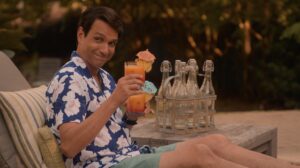 Daniel LaRusso holds up a drink poolside on Cobra Kai season 5