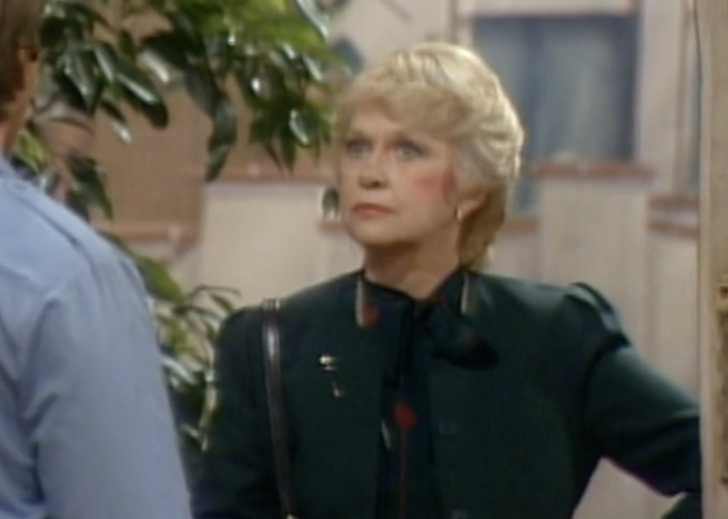 Actress Georgeann Johnson appearing in "Three's Company" with a green jacket and stern look on her face