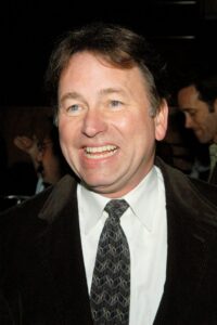Closeup of actor John Ritter smiling in suit and tie