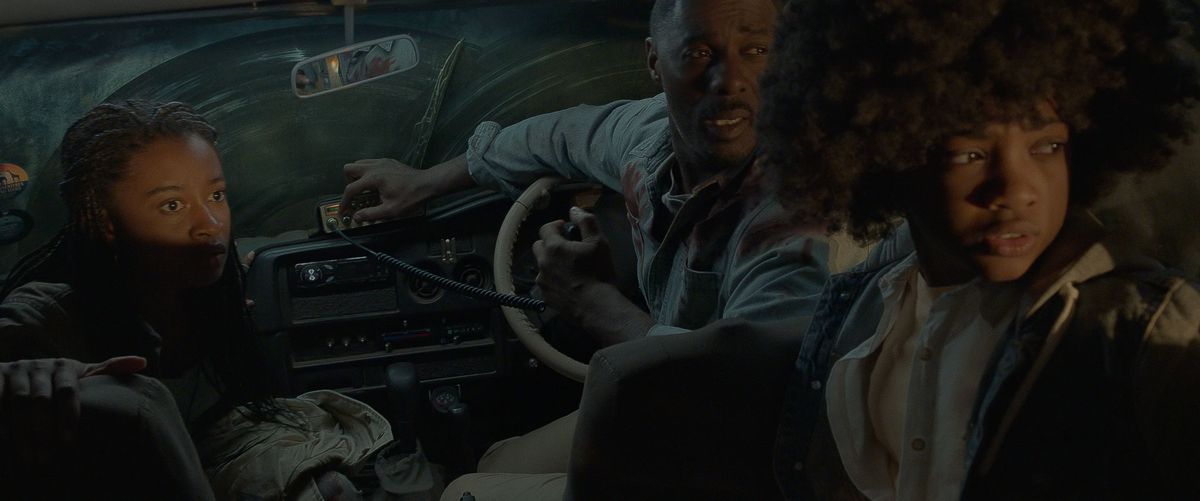Idris Elba, Iyana Halley, and Leah Jeffries look frightened in a car at night in Beast