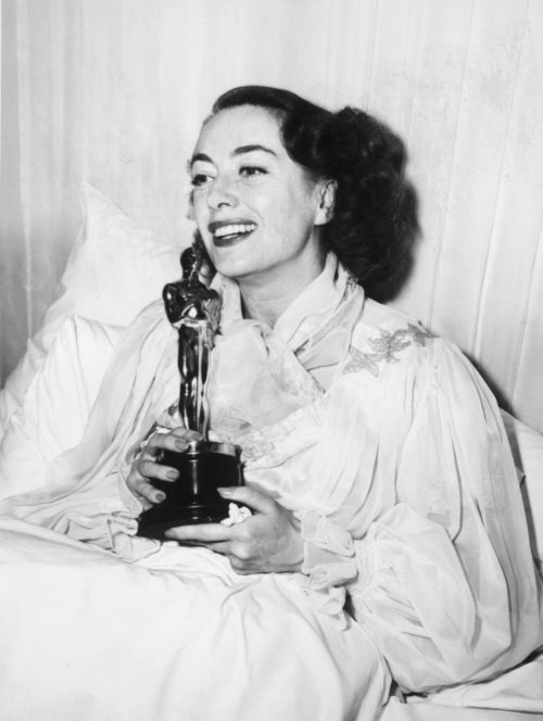 Joan Crawford in bed with her Oscar in 1946