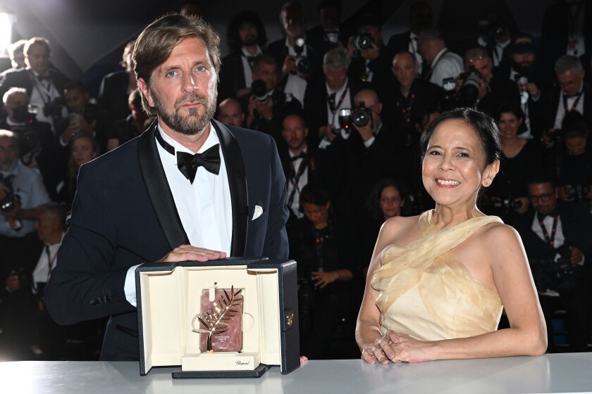 Director Ruben Ostlund and Dolly De Leon pose with the Palme d'Or Award for the movie 'Triangle of Sadness'