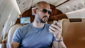 Andre Tate on his phone on a private jet