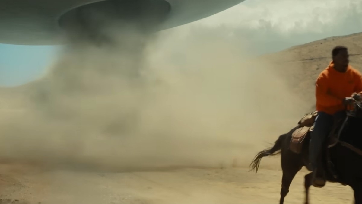 Screenshot from the Nope trailer where a UFO chases a man riding a horse and creates a dust storm
